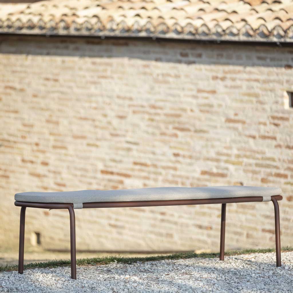 Image of Starling minimalist garden bench seat with rustic building with terracotta tiled roof