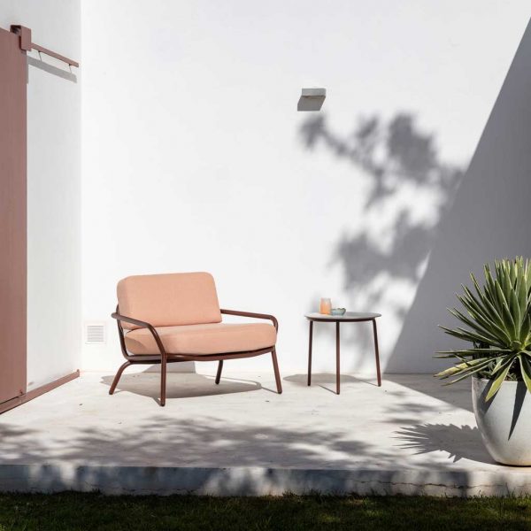 Image of rust-Brown coloured Starling lounge chair in sunny courtyard