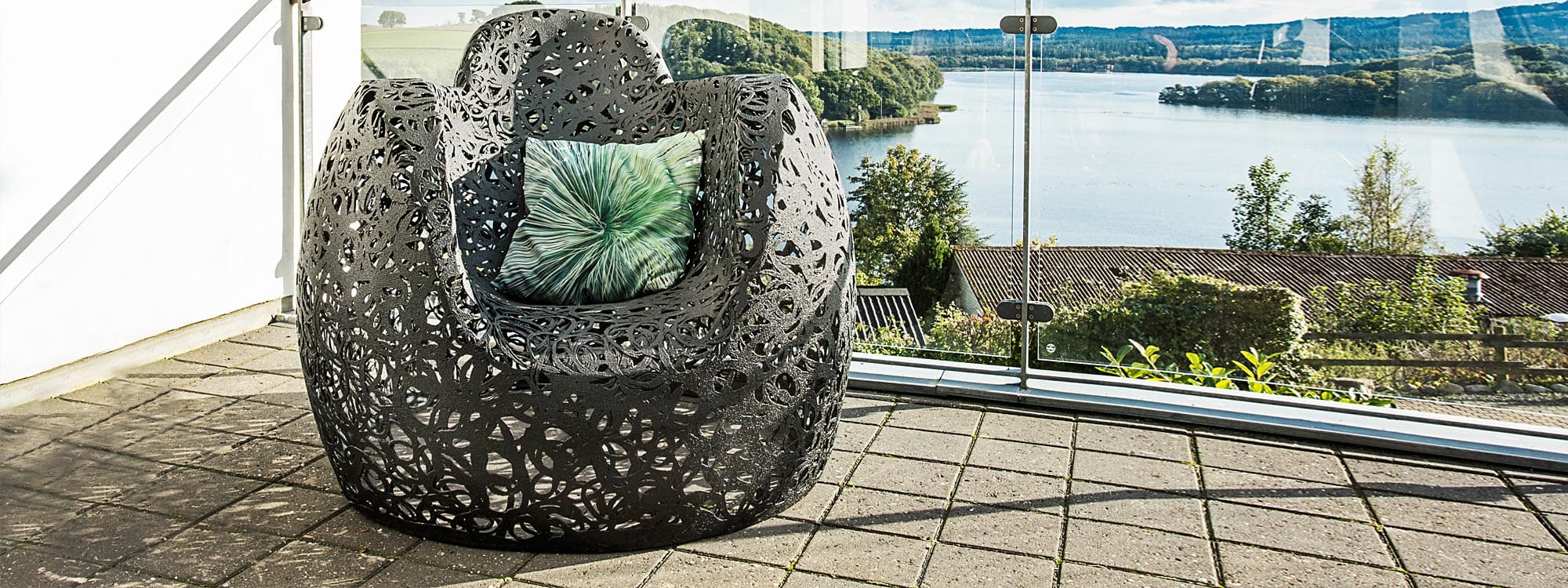 Image of black Stellar lounge chair on rooftop terrace overlooking lake, by Unknown Nordic furniture