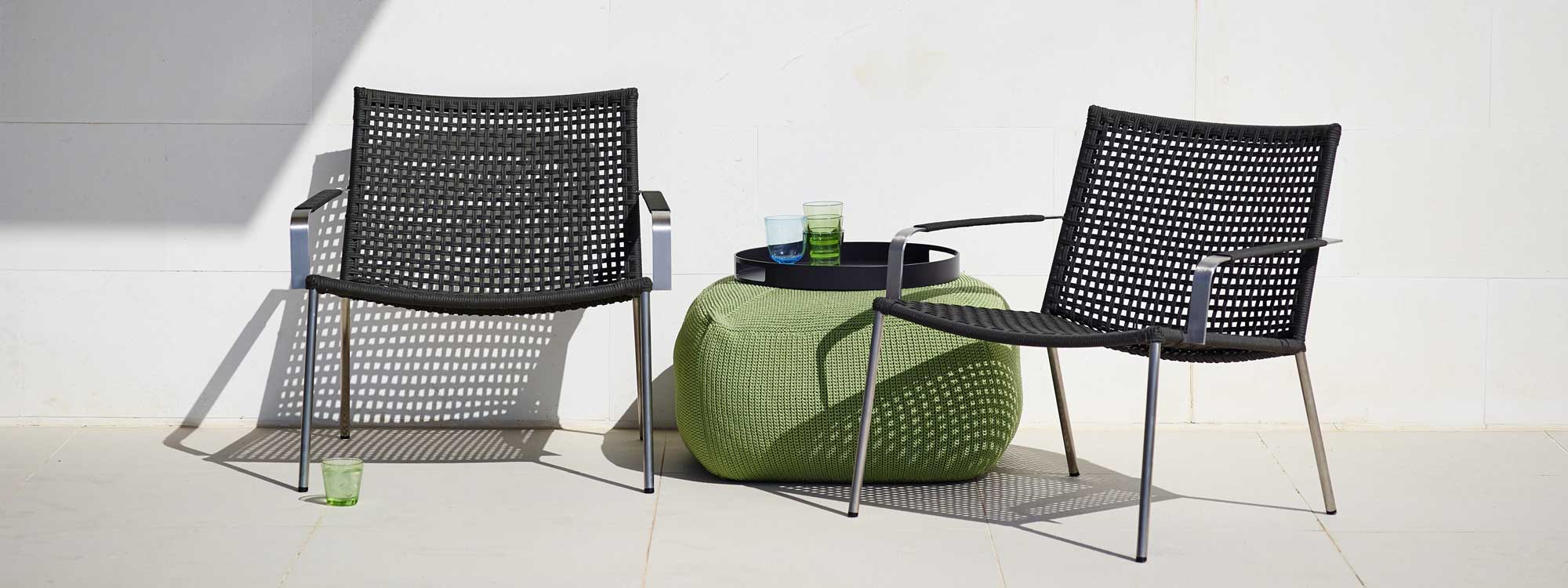 Image of two Straw stainless steel easy chairs and olive-colored Divine foot knotted pouf by Caneline