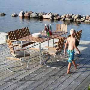 Image of boy walking across wooden decking next to A2 garden furniture by Grythyttan Stålmobler