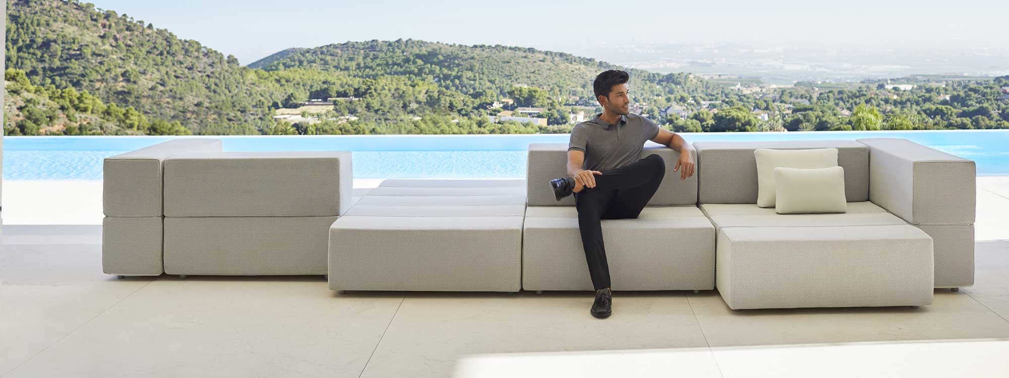 Image of dude sat on Vondom Tablet designer garden sofa with swimming pool and hills in the background