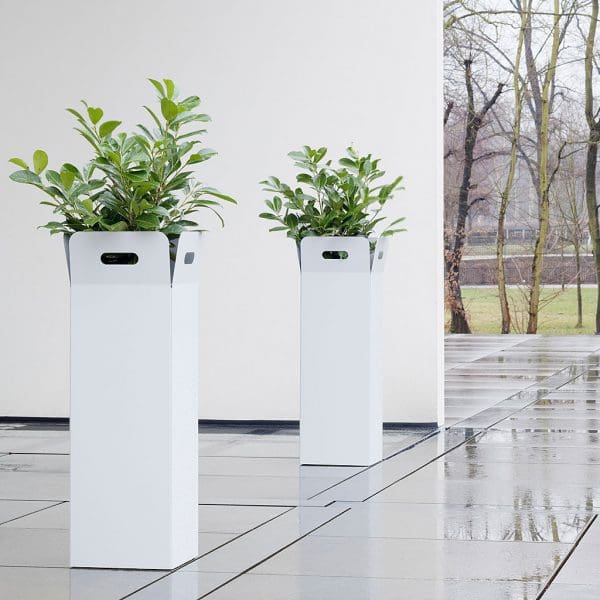 Image of pair of Box tall white planters by Flora, shown on cold and wet wintery terrace