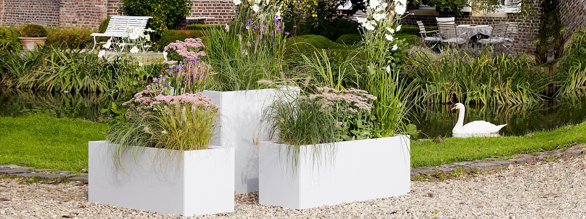 Image of different sizes of Thallo white outdoor plant pots by Flora