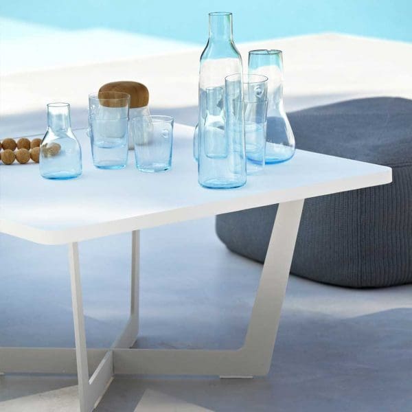 Image of white Time Out garden low table by Cane-line, set with water glasses and carafe