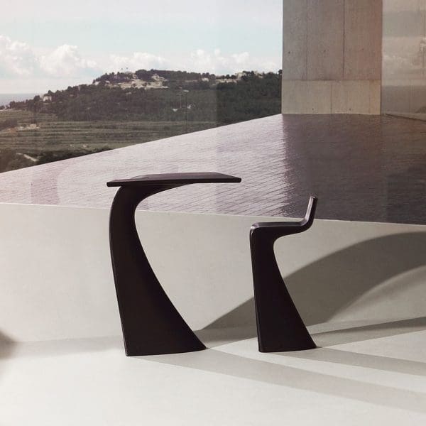 Image of Vondom Wing sculptural bar table and bar stool with modern architecture and hillside in the background