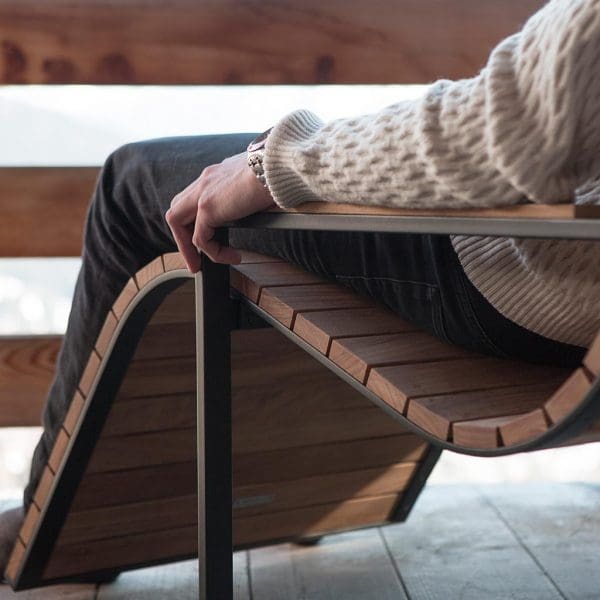 Image of detail of man lying in Garden Sun Chair's contoured teak slats by Roshults