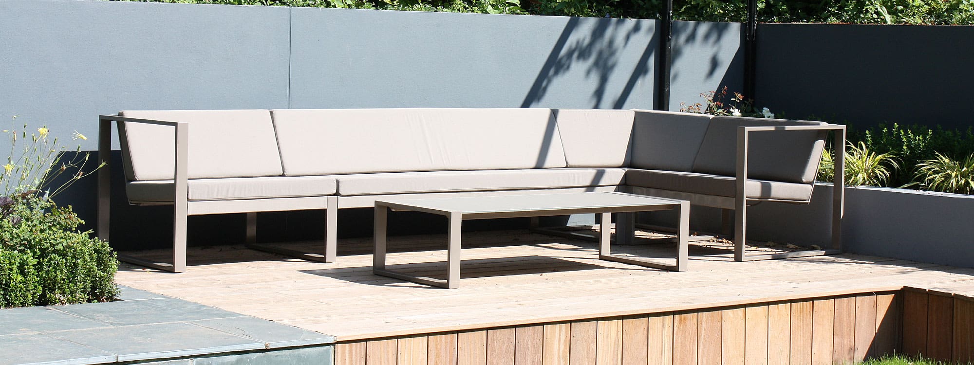 Image of FueraDentro Cima Lounge modern garden corner sofa in taupe on sunny wooden decking