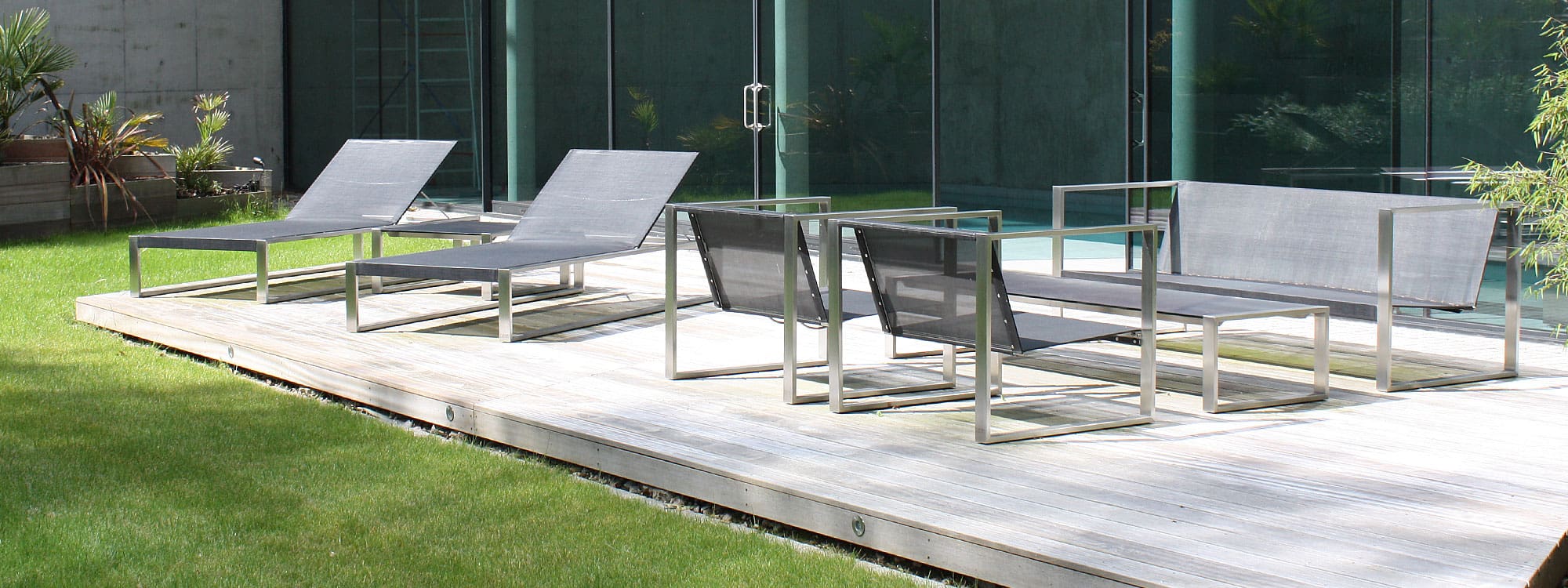 Image of FueraDentro Cima Lounge garden sofa and lounge chairs, together with Siesta minimalist sun loungers on terrace of RIBA award-winning house