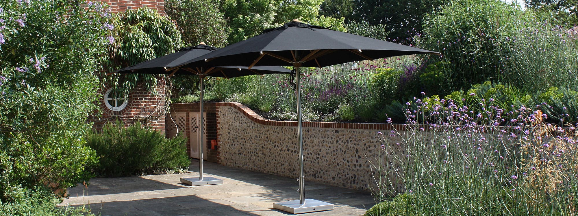 Image of pair of Royal Botania Shady parasols in Meon Valley garden in Hampshire
