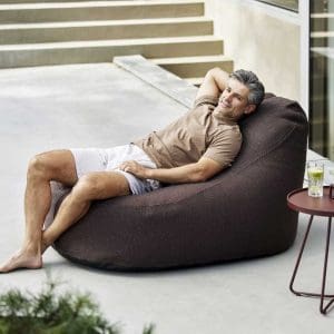 Image of man lying back in Cozy garden bean bag by Cane-line
