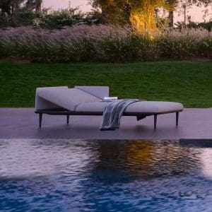 Dusk shot of Styletto upholstered sun loungers by Royal Botania next to swimming pool