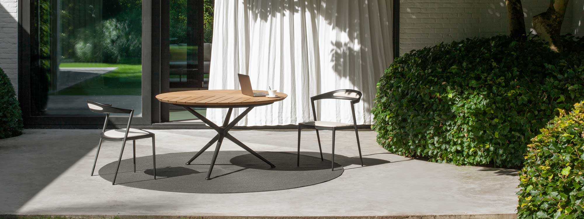Image of Styletto chair and Exes table on minimalist poured concrete terrace