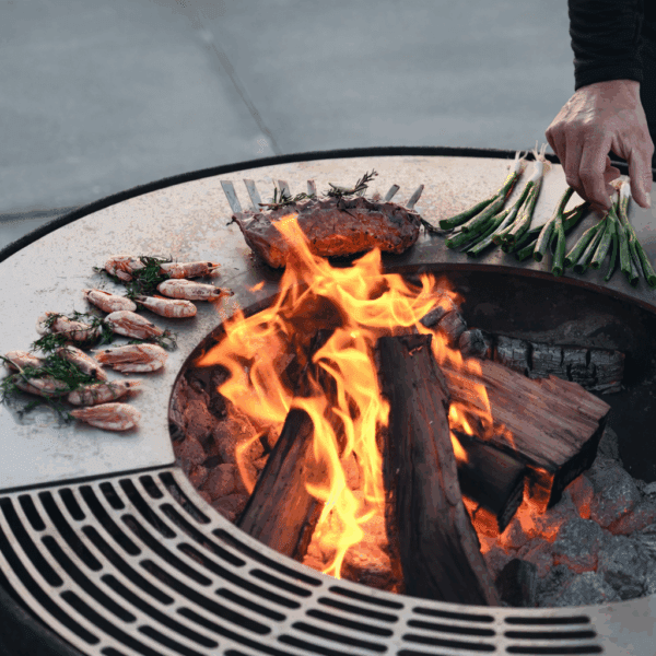 Image of Lava nest fire pit & bbq with food sizzling on the teppanyaki hotplate