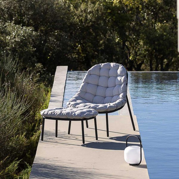 Image of Todus Albus garden chair and foot rest, together with Otus garden lantern, shown on sunny poolside