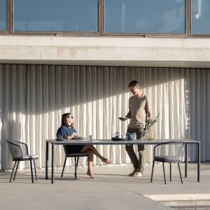 Image of Alca modern garden table and Branta garden chairs in anthracite stainless steel on sunny modern terrace