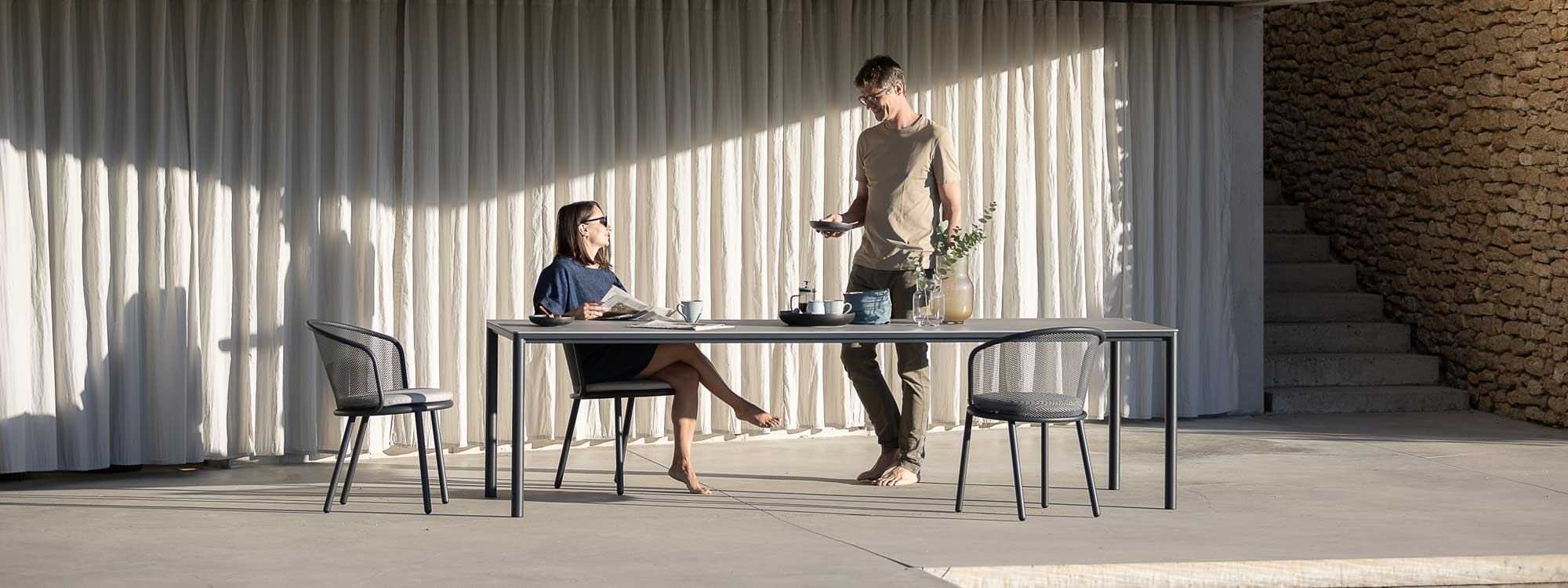 Image of couple around Alca modern rectangular garden table with Baza outdoor chairs on sunny terrace