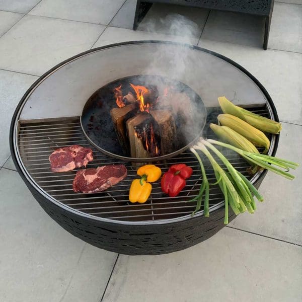 Image of aerial view of meat and vegetables cooking on Lava Nest stainless steel & basalt fiber bbq by Unknown Nordic Furniture