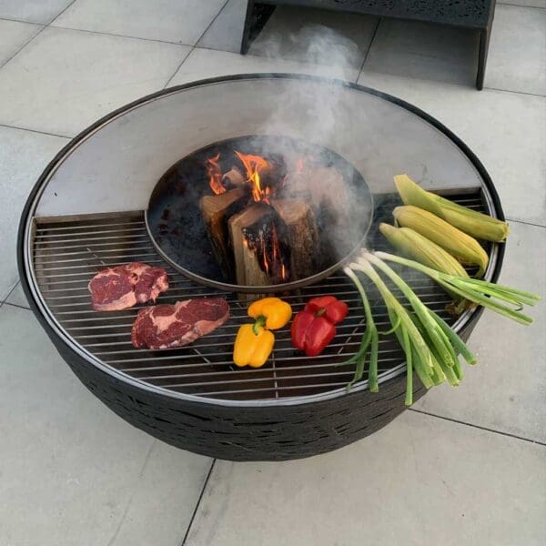 Image of aerial view of meat and vegetables cooking on Lava Nest garden grill & fire pit