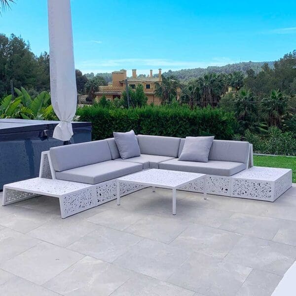 Image of white Bios Lounge garden sofa by Unknown Nordic with lush tropical planting in background