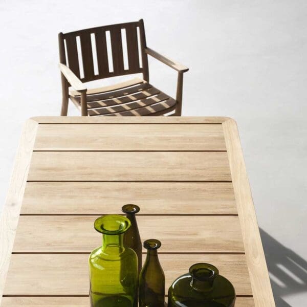 Image of aerial view showing broad teak planks of Levante garden dining table by RODA, with teak carver chair at the end of the table