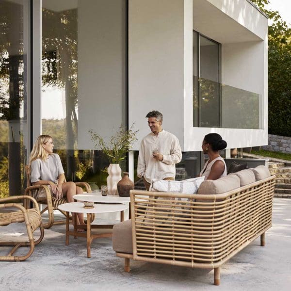 Image of people enjoying Sense cane garden sofa by Cane-line