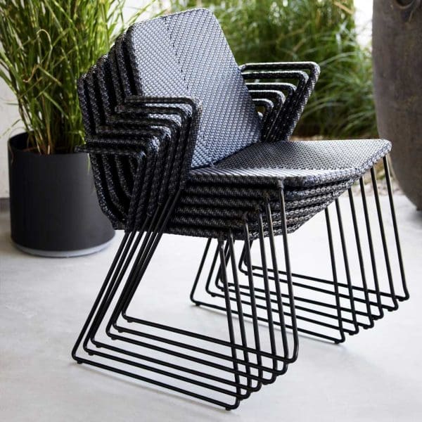 Image of stacked Vision armchairs by Cane-line on poured concrete floor