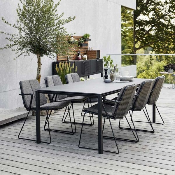 Image of Cane-line Vision chairs and Pure table, with Drop Kitchen and olive tree in background