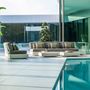 Image of Bari large garden sofa on indoor poolside with cloud-pruned shrub in the background