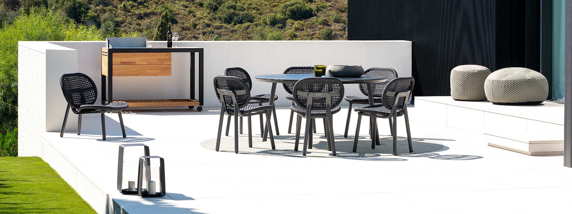 Image of Durham round garden table with Skate modern outdoor chairs in charcoal finish by Jati & Kebon