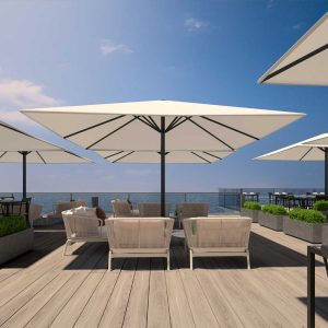 Image of Prostor P8 large white parasol installed above RODA Spool modern white outdoor lounge furniture, shown in sunny terrace with the sea and sky in the background
