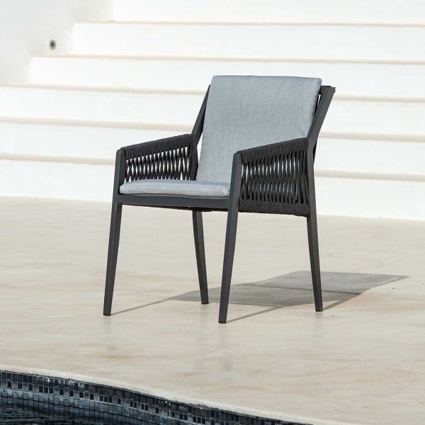 Image of Ritz charcoal colored aluminium garden chair with light grey back and seat cushions, shown on sunny poolside with whitewashed flight of stairs in the background