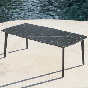 Image of Ritz modern aluminium garden table with charcoal coloured frame and dark marble ceramic top, casting shadows in late afternoon on sunny terrace