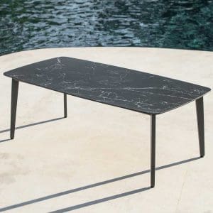 Image of Ritz modern aluminium garden table with charcoal coloured frame and dark marble ceramic top, casting shadows in late afternoon on sunny terrace