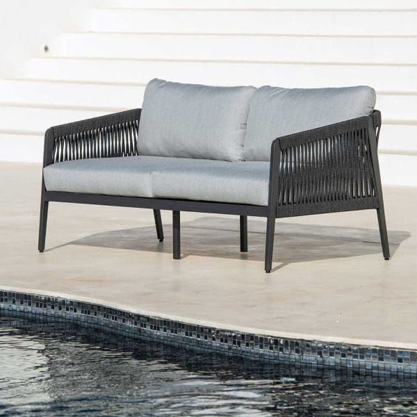 Image of Ritz contemporary 2 seat garden sofa with charcoal frame and light grey back and seat cushions, shown on sunny poolside