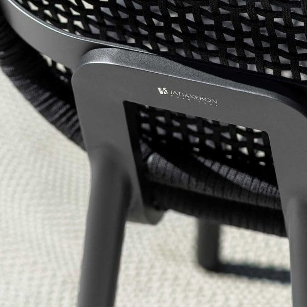 Image of detail of Skate garden chair's polyolefin woven back and charcoal aluminium frame, shown with Jati & Kebon logo