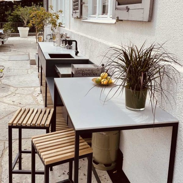 Image of Ticino Frame's raised bistro table in anthracite stainless steel and Light Grey ceramic table top