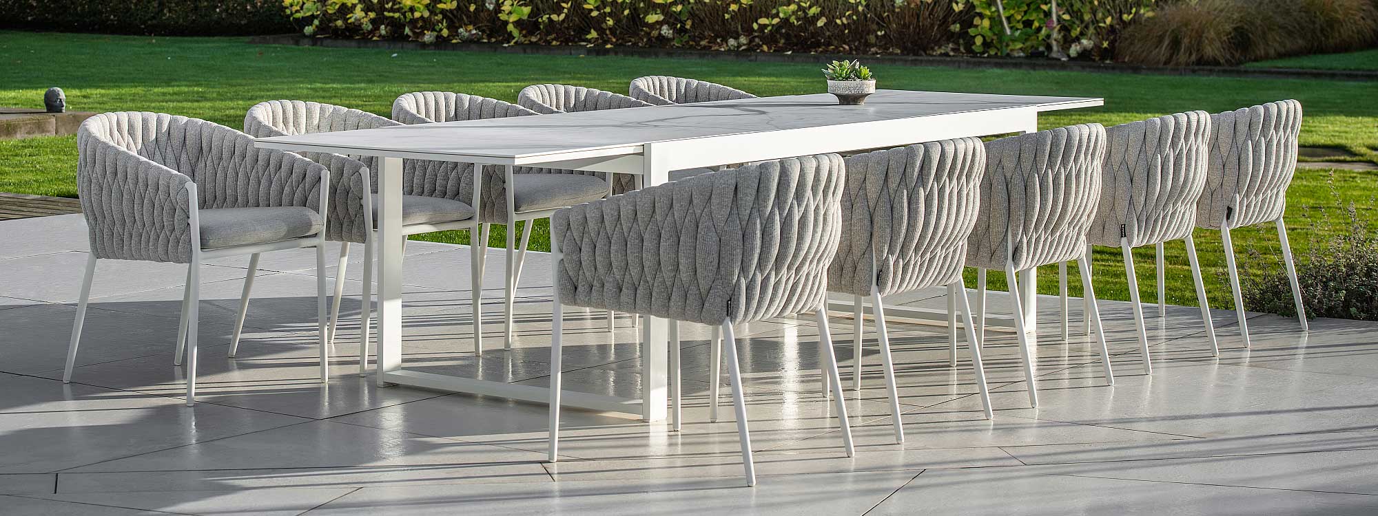 Image of Vigo XL extending garden table with graduario marble-effect ceramic top, shown with Fortuna Rope outdoor dining chairs by Jati & Kebon