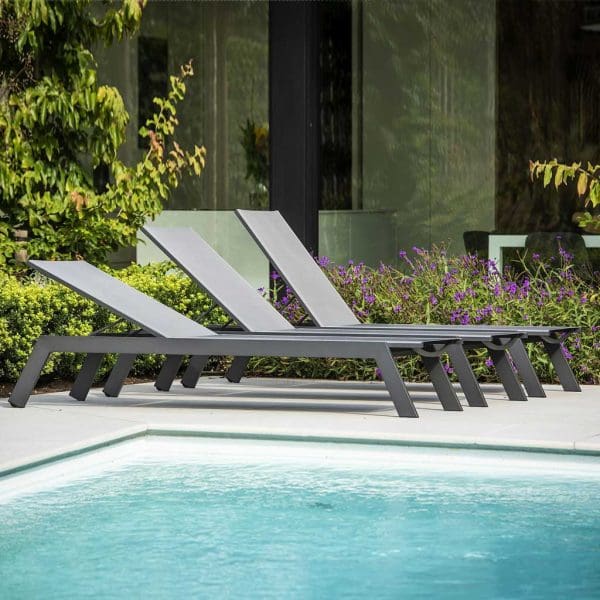 Image of row of 3 Vigo XL sun loungers with back rests adjusted into different positions, shown in sunny poolside