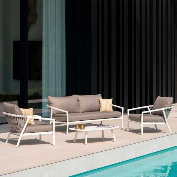 Image of Jati & Kebon white garden lounge set with taupe cushions on sunny poolside