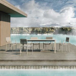 Image of Oiside 45 modern garden dining furniture on wooden decking, surrounded by chilly water, with snowy mountains and cloudy sky in the background