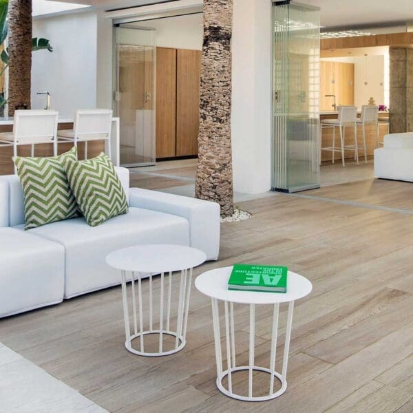 Image of Elements white garden sofa on decking in front of house, with palm tree trunk in the background