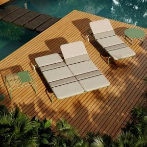 Image of Oiside No 12 modern sun loungers with tubular aluminium frames, shown on wooden decking surrounded by water and exotic plants