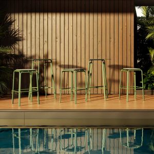 Image of Oiside No 12 green outdoor bar furniture on poolside, with reflection of the furniture shown in the still waters below