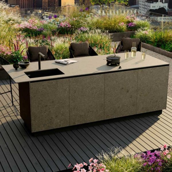 Image of OiCook modern garden kitchen island with lush grasses and flowerbeds in the background