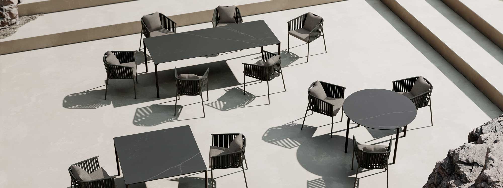 Image of aerial view of Oiside Twist outdoor carver chairs and garden tables in different shapes and sizes, shown on bright sunny terrace