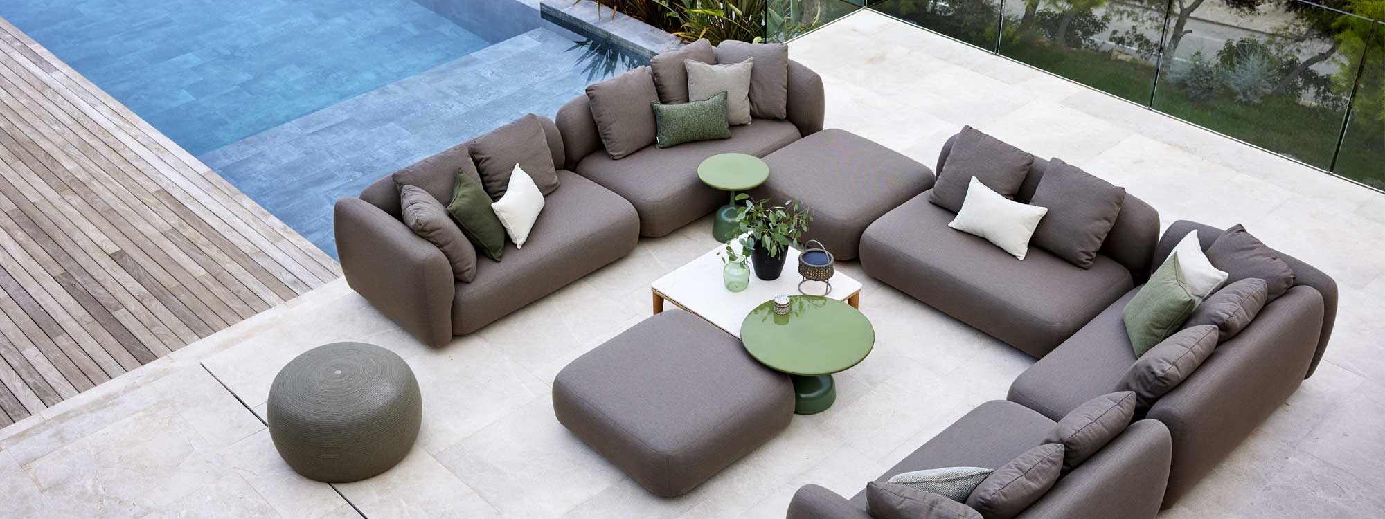 Image of aerial view of Cane-line Capture modular garden sofa and ottoman shown on terrace next to swimming pool