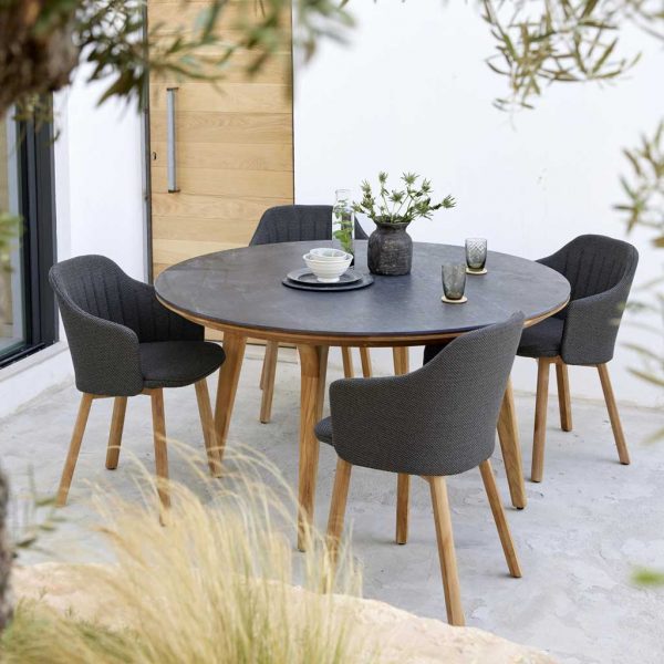 Image of Aspect circular teak table with black ceramic table top together with Choice contemporary teak dining chairs by Cane-line