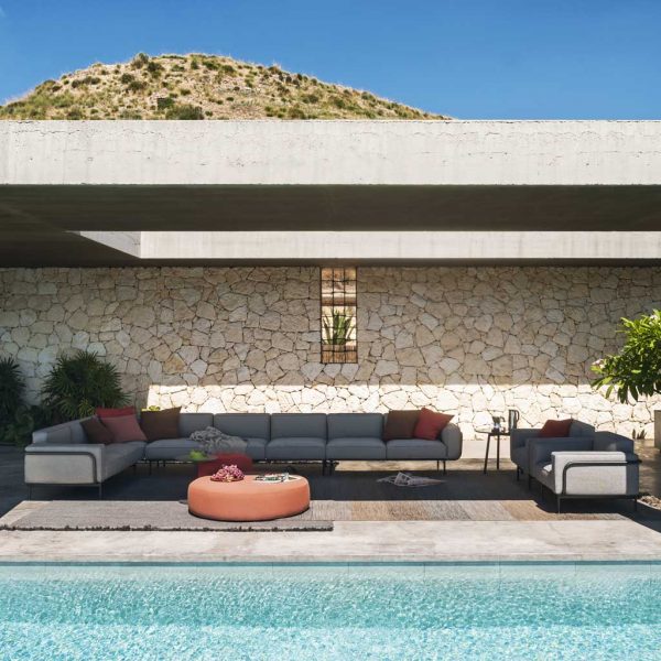Image of RODA Estendo large outdoor sofa, lounge chairs and Double modern outdoor poufs on shady poolside terrace