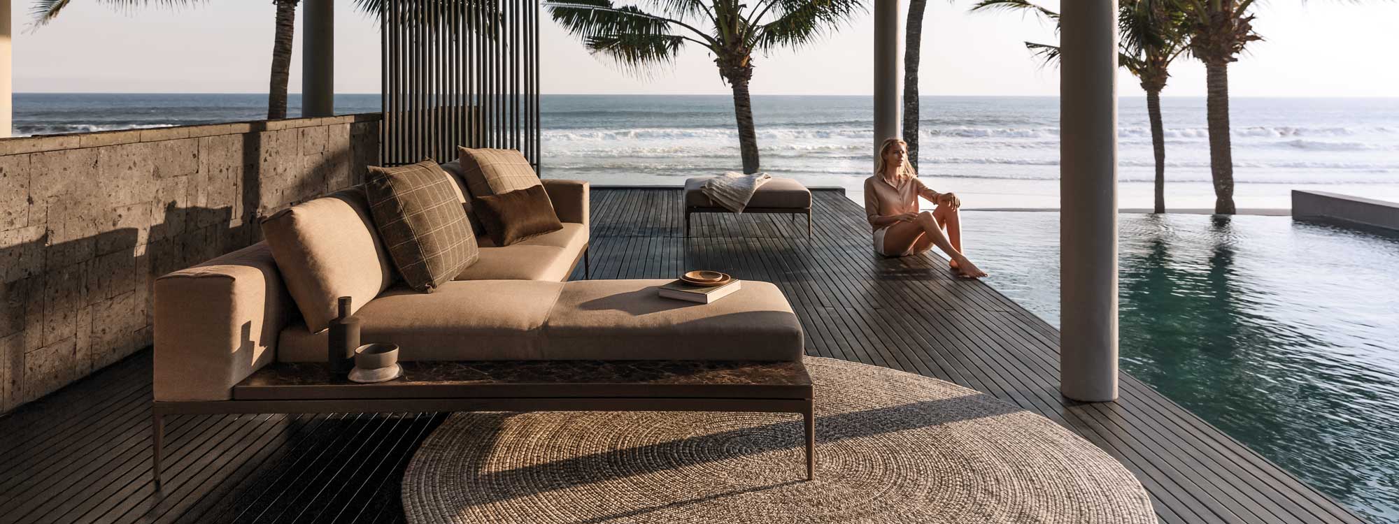 Image of Grid luxury garden sofa with chaise with frame in Java-brown aluminium, light brown cushions and Emperor marble-effect ceramic by Gloster.
